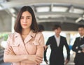 Serious business woman with arms crossed standing in front of team, looking at camera Royalty Free Stock Photo