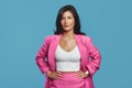 Serious business woman dressed in stylish pink suit holding hands on waist Royalty Free Stock Photo