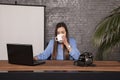 Serious business woman is drinking coffee, copy space behind her