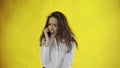 Serious business woman talking mobile phone on yellow background. Portrait of young businesswoman calling phone in Royalty Free Stock Photo