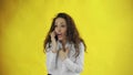 Serious business woman talking mobile phone on yellow background. Portrait of young businesswoman calling phone in Royalty Free Stock Photo