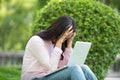 Serious business woman work hard with serious problem in a public park. Working on laptop outdoors. Royalty Free Stock Photo