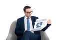 serious businessman in eyeglasses reading newspaper while sitting in armchair Royalty Free Stock Photo