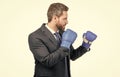 Serious businessman in formal suit and boxing gloves in fighting position isolated on white, fight