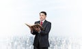 Serious businessman holding open old book