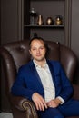 Serious businessman in a leather armchair and premium interior.