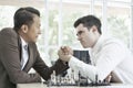 Serious businessman playing board chess game together, Competition and Strategy planning success ideas. Chess board game concept Royalty Free Stock Photo