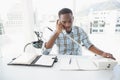 Serious businessman reading desk diary and phoning