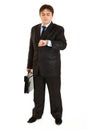 Serious businessman with suitcase looking at watch Royalty Free Stock Photo