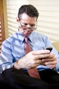 Serious businessman texting on mobile phone Royalty Free Stock Photo