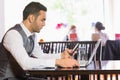 Serious businessman using phone while working on laptop Royalty Free Stock Photo