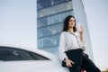 Serious businessman woman standing near a car drinking coffee outdoors. Royalty Free Stock Photo