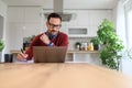 Serious businessman working over the laptop and writing notes in notepad, sitting in home office Royalty Free Stock Photo