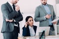 serious businesspeople looking at laptop