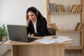 Serious businesswoman in headphones watching webinar on laptop, learning studying computer course, making call Royalty Free Stock Photo