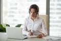 Serious businesswoman in headphones watching webinar on laptop m Royalty Free Stock Photo