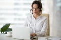 Serious businesswoman with laptop in headset making online confe