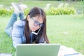 Serious businesswoman laydown and work hard on a green grass fields Royalty Free Stock Photo