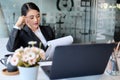 Serious businesswoman sitting in front of laptop computer at her workplace and reading financial reports Royalty Free Stock Photo