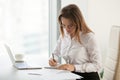 Serious businesswoman taking notes during routine office morning Royalty Free Stock Photo