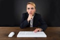 Serious Businesswoman Using Computer Mouse And Keyboard On Desk Royalty Free Stock Photo