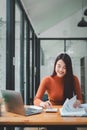 Serious businesswoman using on laptop holding papers preparing report analyzing work results Royalty Free Stock Photo