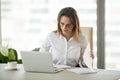 Serious businesswoman working with laptop documents analyzing pr