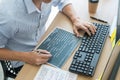 Serious busy hipster young web software developer programmer is coding or programming on a desktop computer information in modern Royalty Free Stock Photo