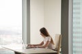 Serious busy woman working on laptop in office interior, copyspa Royalty Free Stock Photo