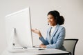 Serious call center operator in wireless headset talking with customer, woman in headphones with microphone consulting client on Royalty Free Stock Photo