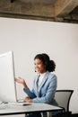 Serious call center operator in wireless headset talking with customer, woman in headphones with microphone consulting client on Royalty Free Stock Photo