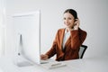 Serious call center operator in wireless headset talking with customer, woman in headphones with microphone consulting client on Royalty Free Stock Photo