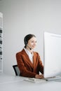 Serious call center operator in wireless headset talking with customer, woman in headphones with microphone consulting client on Royalty Free Stock Photo