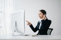 Serious call center operator in wireless headset talking with customer, woman in headphones with microphone consulting client on Royalty Free Stock Photo