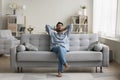 Serious calm young Indian man resting on home couch