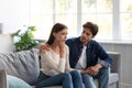 Serious careful young european guy calms upset unhappy lady in living room interior Royalty Free Stock Photo