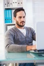 Serious casual businessman working on laptop at his desk Royalty Free Stock Photo