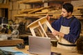 Serious carpenter deals with making wooden chair Royalty Free Stock Photo