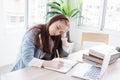 Serious Caucasian girl student is writing on notebook. She so bored about online learning and doing many homework with laptop at Royalty Free Stock Photo