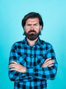Serious caucasian hipster with brunette hair having perfect beard and moustache crossed hands, barber