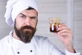 Serious chef with jar of honey nuts. Healthy breakfast. Bearded man in chef uniform with honeyed assorted nuts in glass