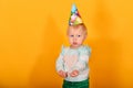 A serious child with a cap on his head shows his hands