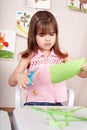 Serious child cutting paper.