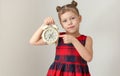 Serious child holding alarm clock and showing index finger on it Royalty Free Stock Photo