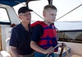 A serious child learns sailing from his grandfather Royalty Free Stock Photo