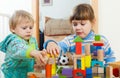 Serious children playing with wooden blocks