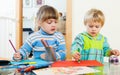 Serious children sketching with paper and pencils