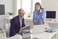 Serious company employees working on project together and studying information on laptop screen Royalty Free Stock Photo