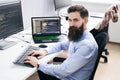 Serious computer programmer developer working in IT office, sitting at desk and coding, working on a project in software Royalty Free Stock Photo