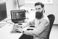 Serious computer programmer developer working in IT office, sitting at desk and coding, working on a project in software Royalty Free Stock Photo